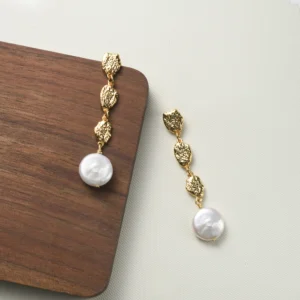 Gold coin and pearl drop earrings with sculptural elegance. Be the gliding grace.