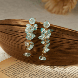 Gold earrings with seashell drop design and curved structure. Be the Gliding Grace.